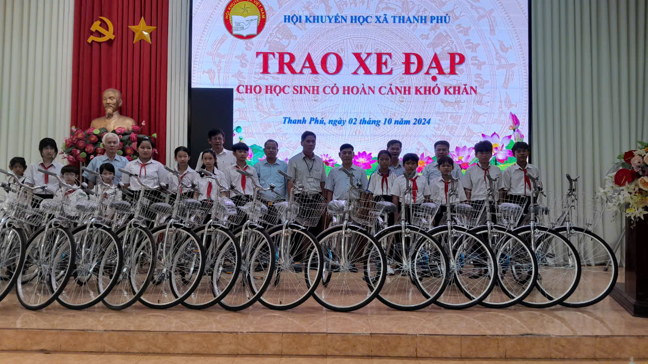 Lãnh đạo xã chụp hình trao xe cho các em học sinh